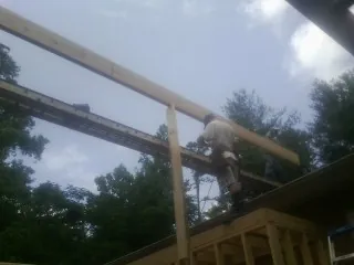 Carpenter setting a ridge beam over a new addition frame — Ice Dam Removal by Roofing Brothers in Center Sandwich