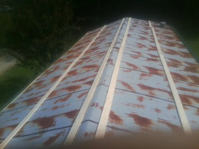 Rusted metal roof panels with new wood purlins before replacement — Storm Damage Roof Repair in Center Sandwich by Roofing Brothers