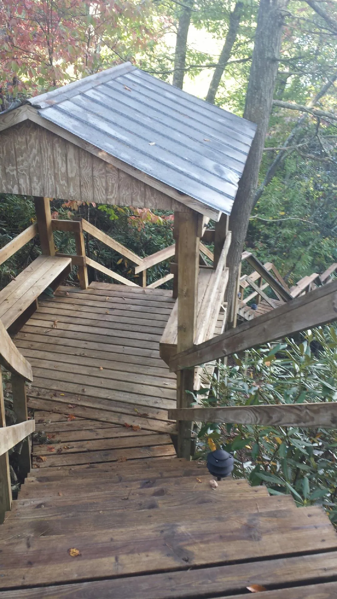 Metal roofed shelter over wooden steps on a wooded walkway — Skylight Repair & Installation work by our crew in Center Sandwich