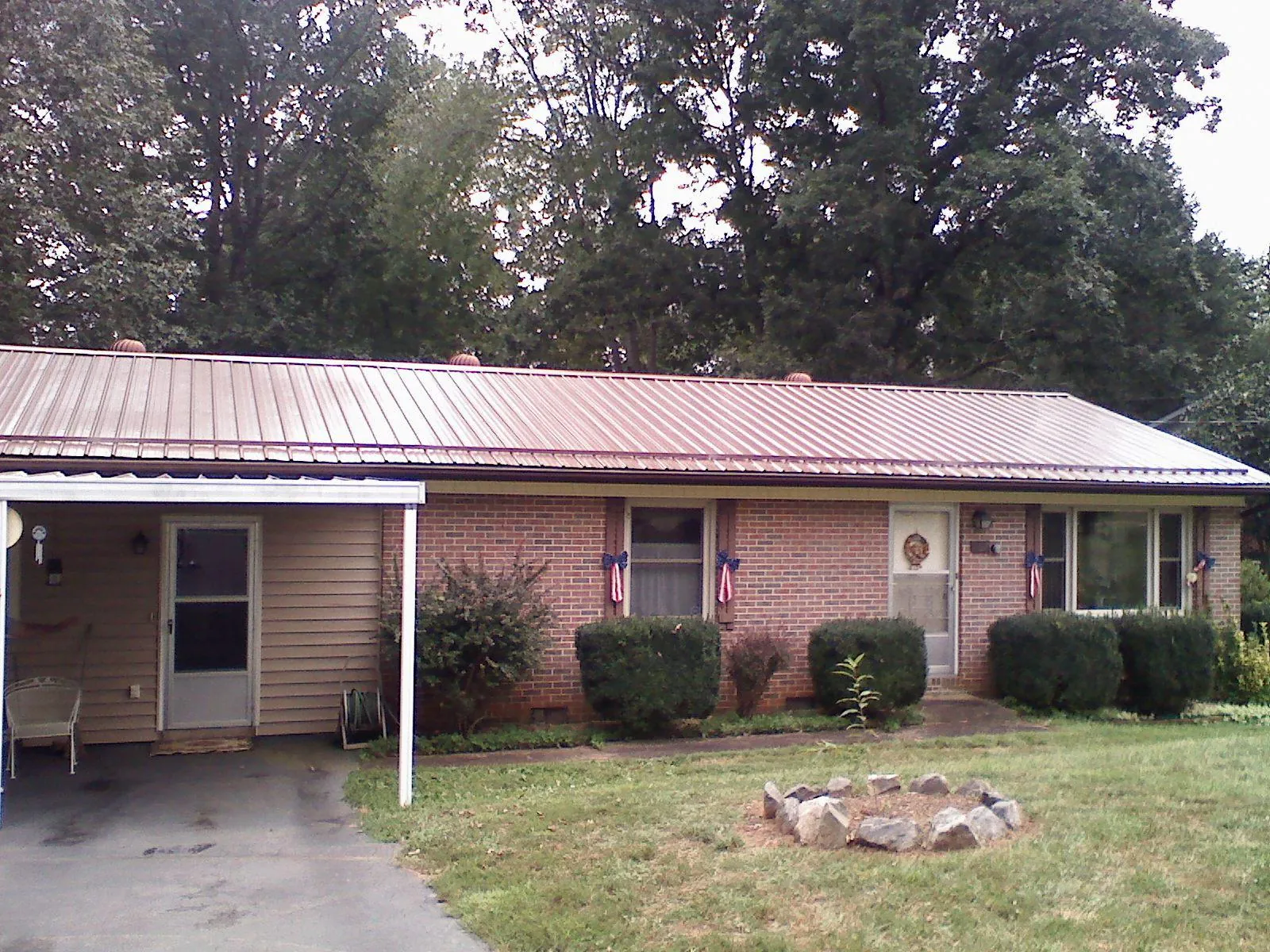 Bronze metal roof and carport on a brick ranch home — Roof Repair work by our crew in Center Sandwich